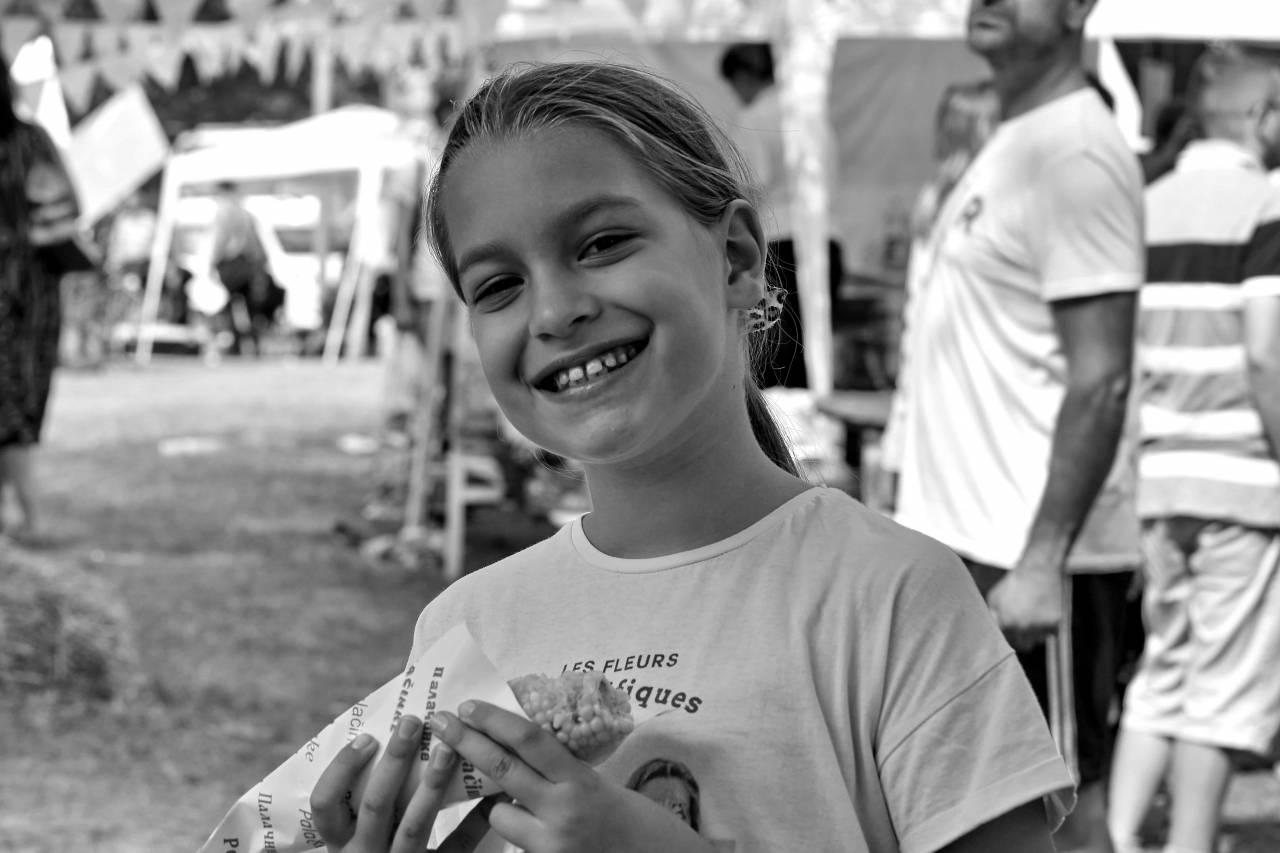 corn carnival eating portrait happiness festival pretty child street lips face looking  — free black and white photo