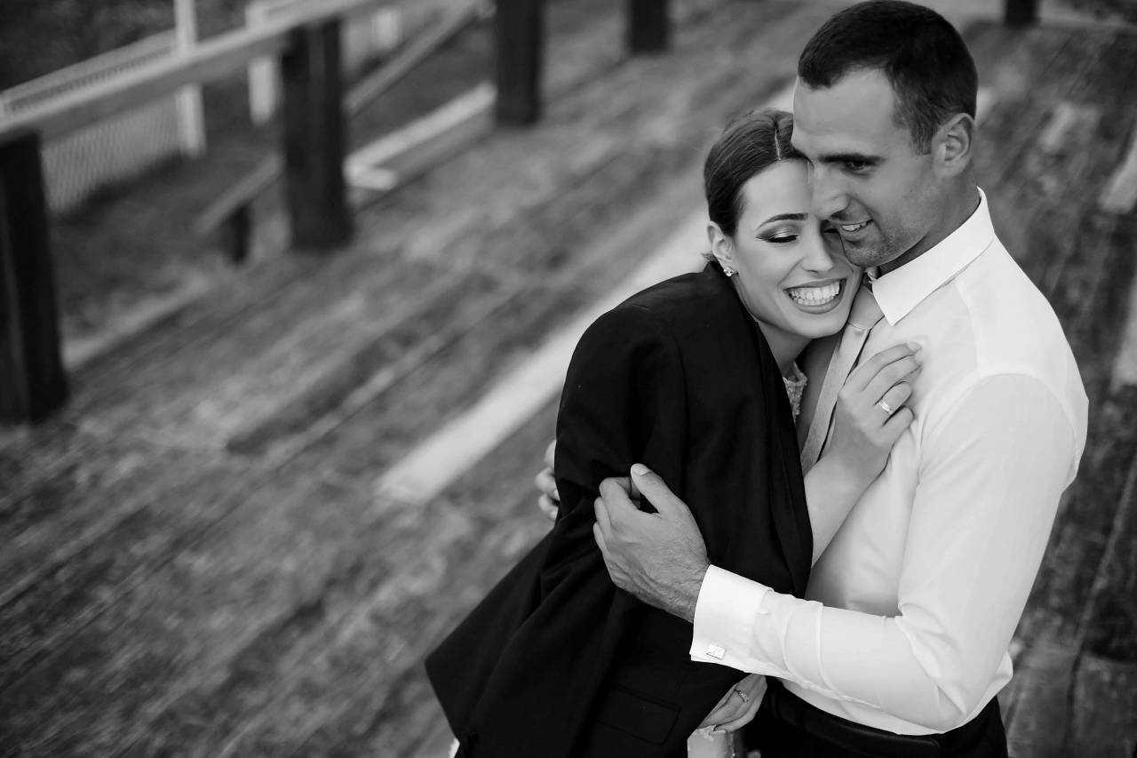 romance togetherness businesswoman businessman hugging affection outdoors couple — free black and white photo