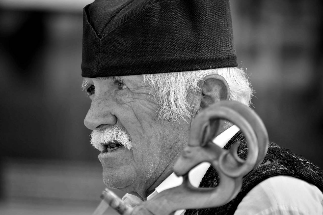 side musician portrait elderly outdoors elder street face beard handsome mouth kb finger  — free black and white photo