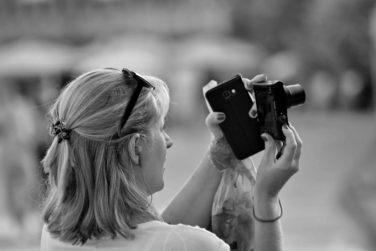 urban cellphone fun tourist attraction camera area woman instrument outdoors street — free black and white photo
