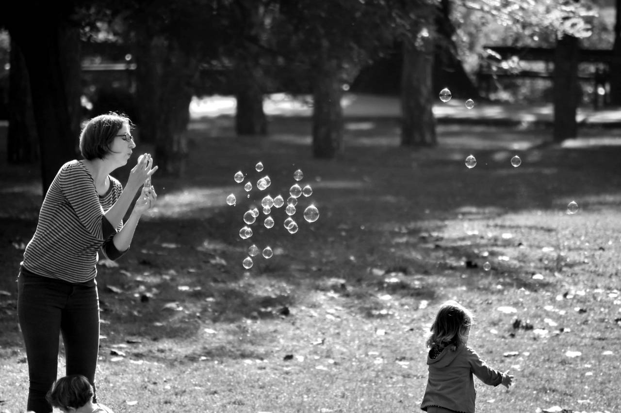 park child outdoors motherhood togetherness playful childhood grass  — free black and white photo