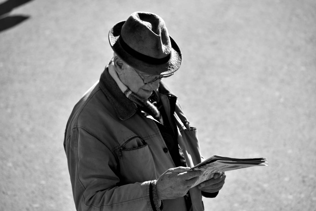 grandfather newspaper eyeglasses hat senior reading pensioner uniform man  — free black and white photo