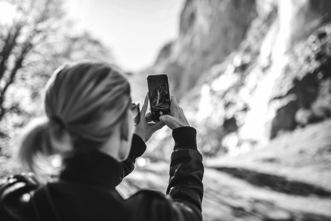 Woman Taking Mobile Photograph  — free black and white photo