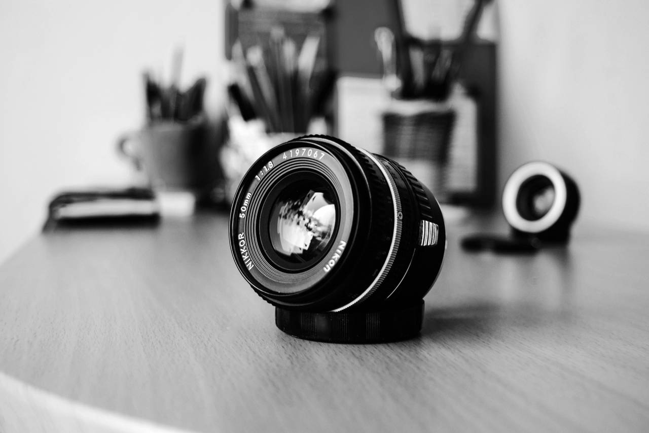 Camera Lens on Desk  — free black and white photo