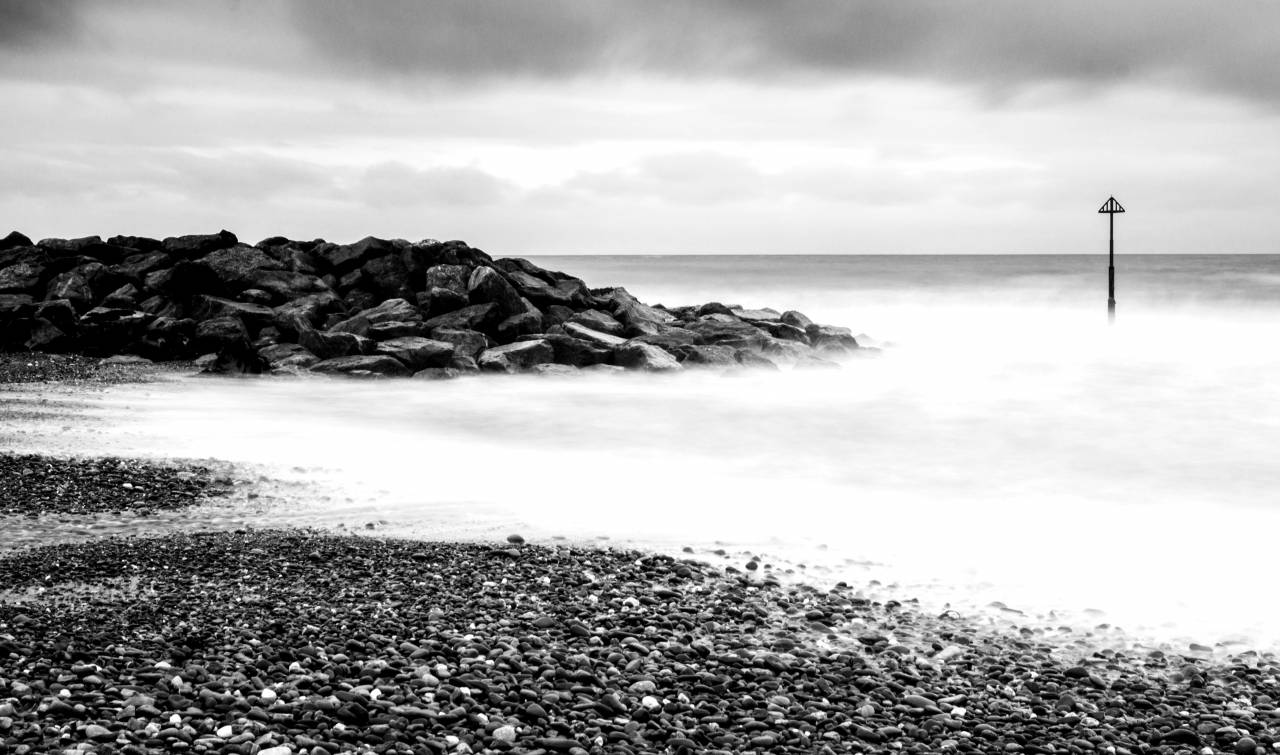   beach  sea  coast  sand  rock  ocean  — free black and white photo