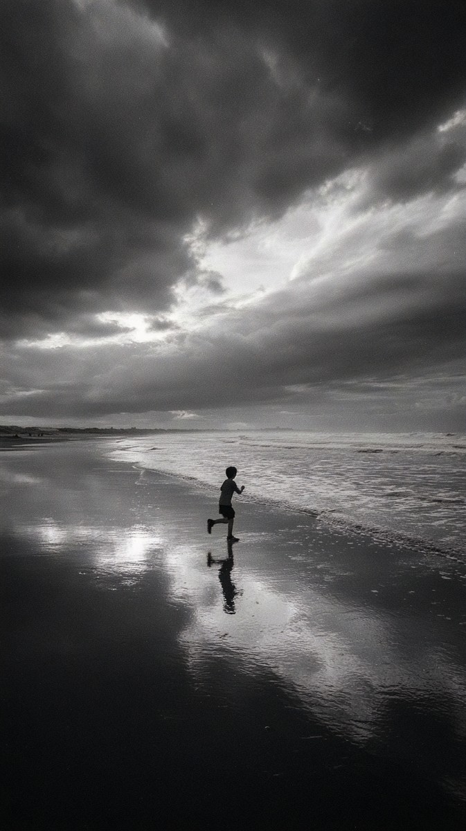 child running beach reflection wet sand light shimmering ref — free black and white photo