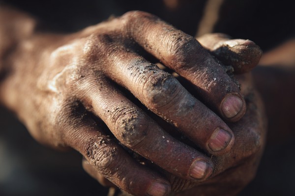 close up photograph of human hands working rough texture dirt — black and white nature photo
