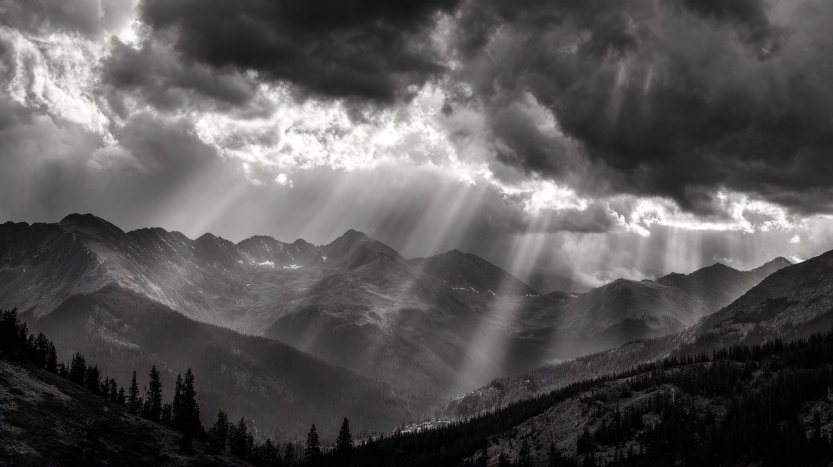 dramatic mountain range landscape storm clouds gathering rays — free black and white photo