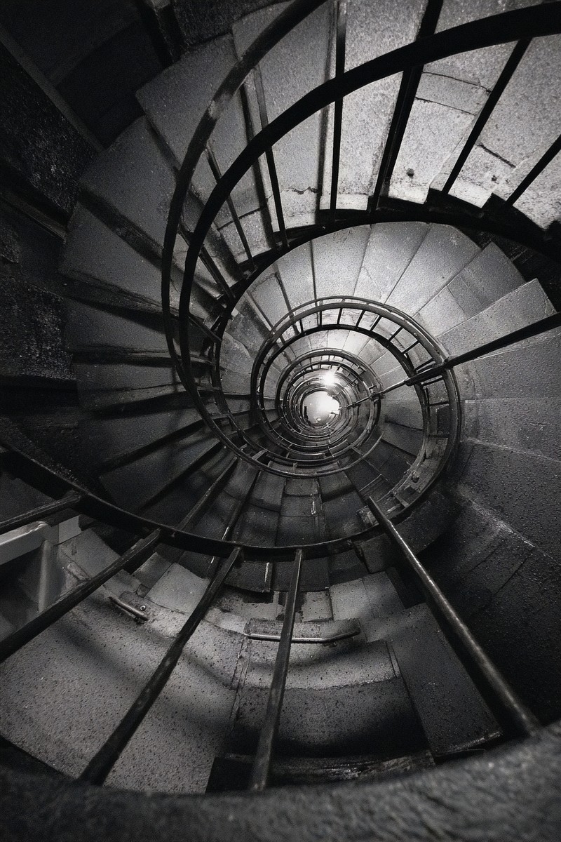 fine art photograph of a spiral staircase looking down hypnot — free black and white photo