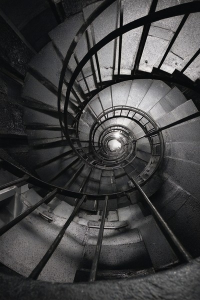 fine art photograph of a spiral staircase looking down hypnot — black and white photo