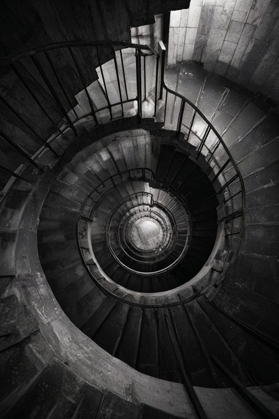 fine art photograph of a spiral staircase looking down hypnot — black and white photo