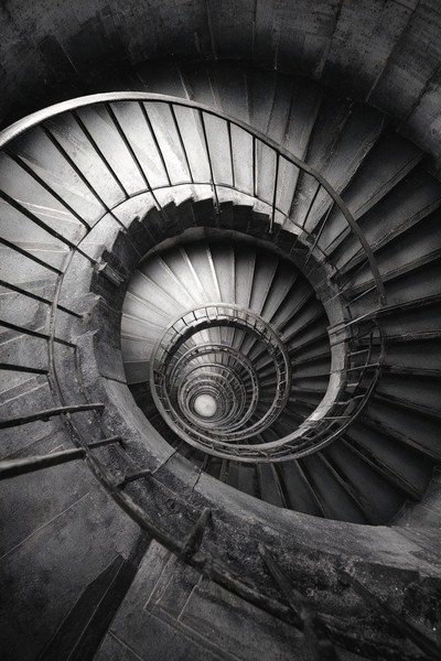 fine art photograph of a spiral staircase looking down hypnot — black and white photo