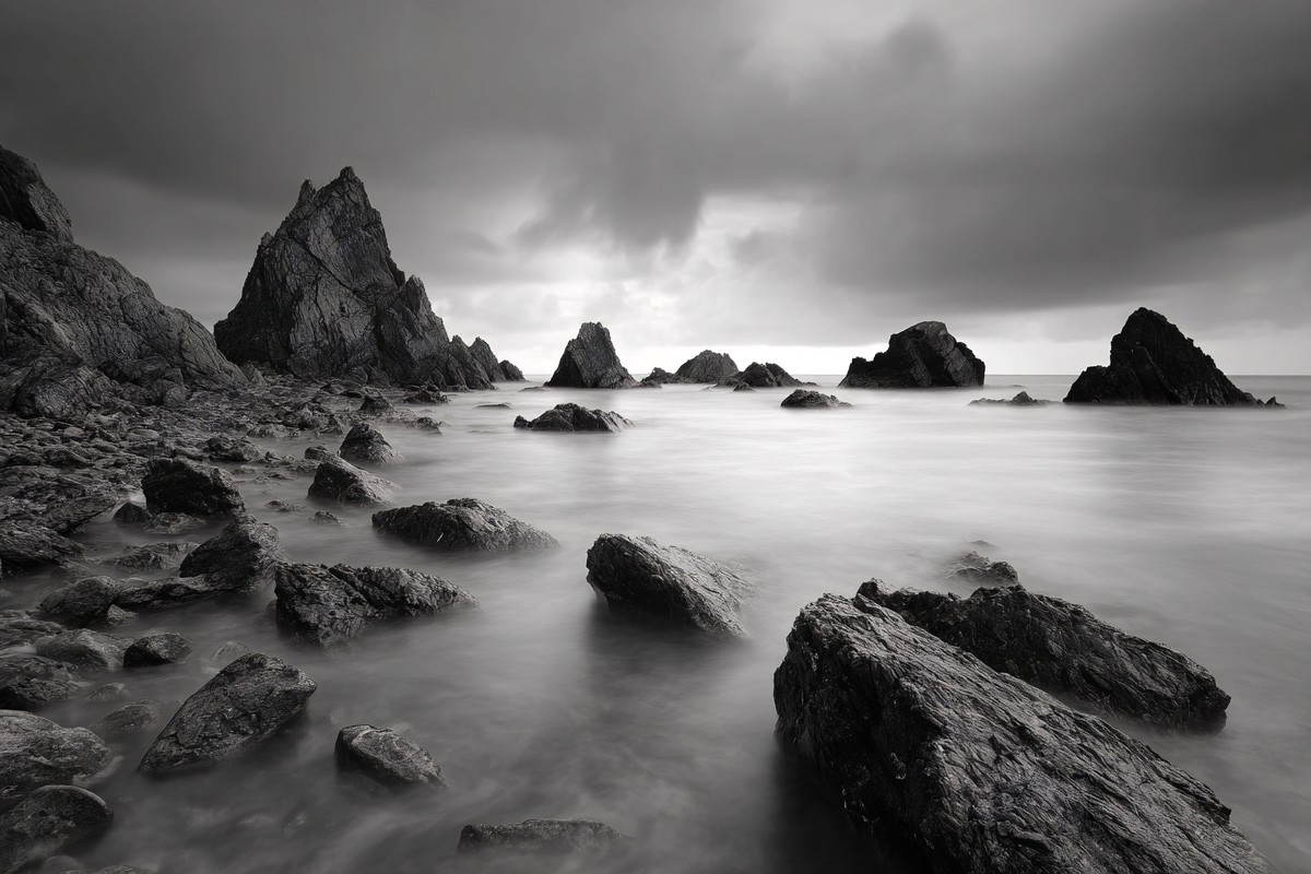 long exposure seascape silky smooth water moving around jagge — free black and white photo