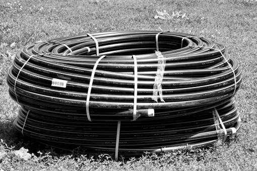 industrial pipe grassland meadow pipeline plastic piping outdoors grass object  — black and white photo