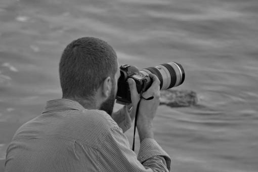 photojournalist device beach lens photographer professional man instrument nature water